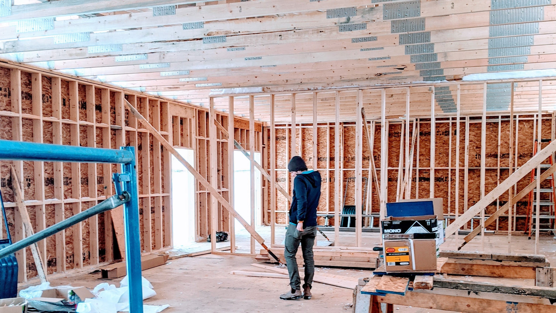 Image of Todd the co-founder of Alkeme standing in the production space as it's being built.  Walls are down to the studs as its being built.