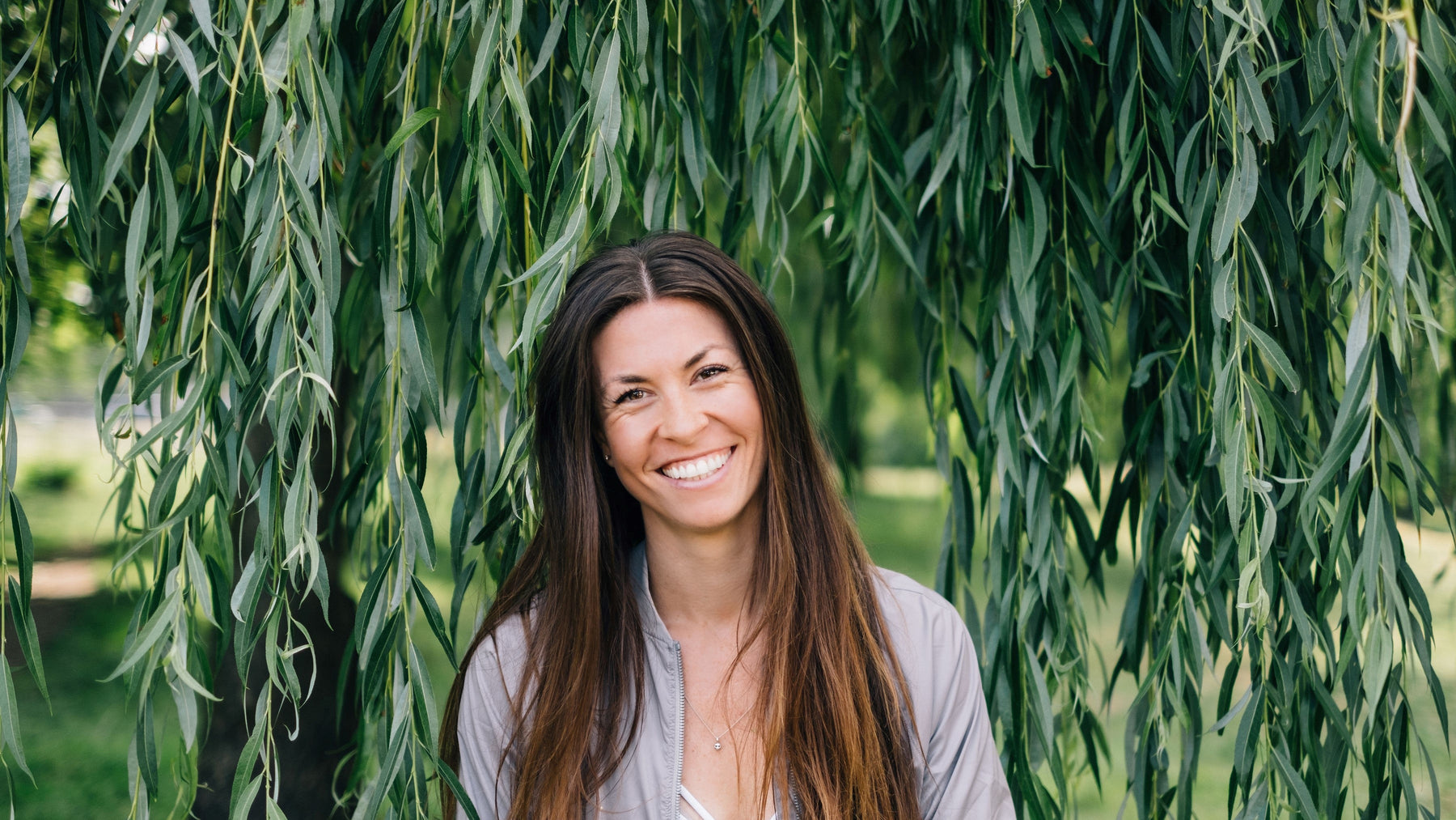 Jordan Bruce registered holistic nutritionist at the park in front of a willow tree