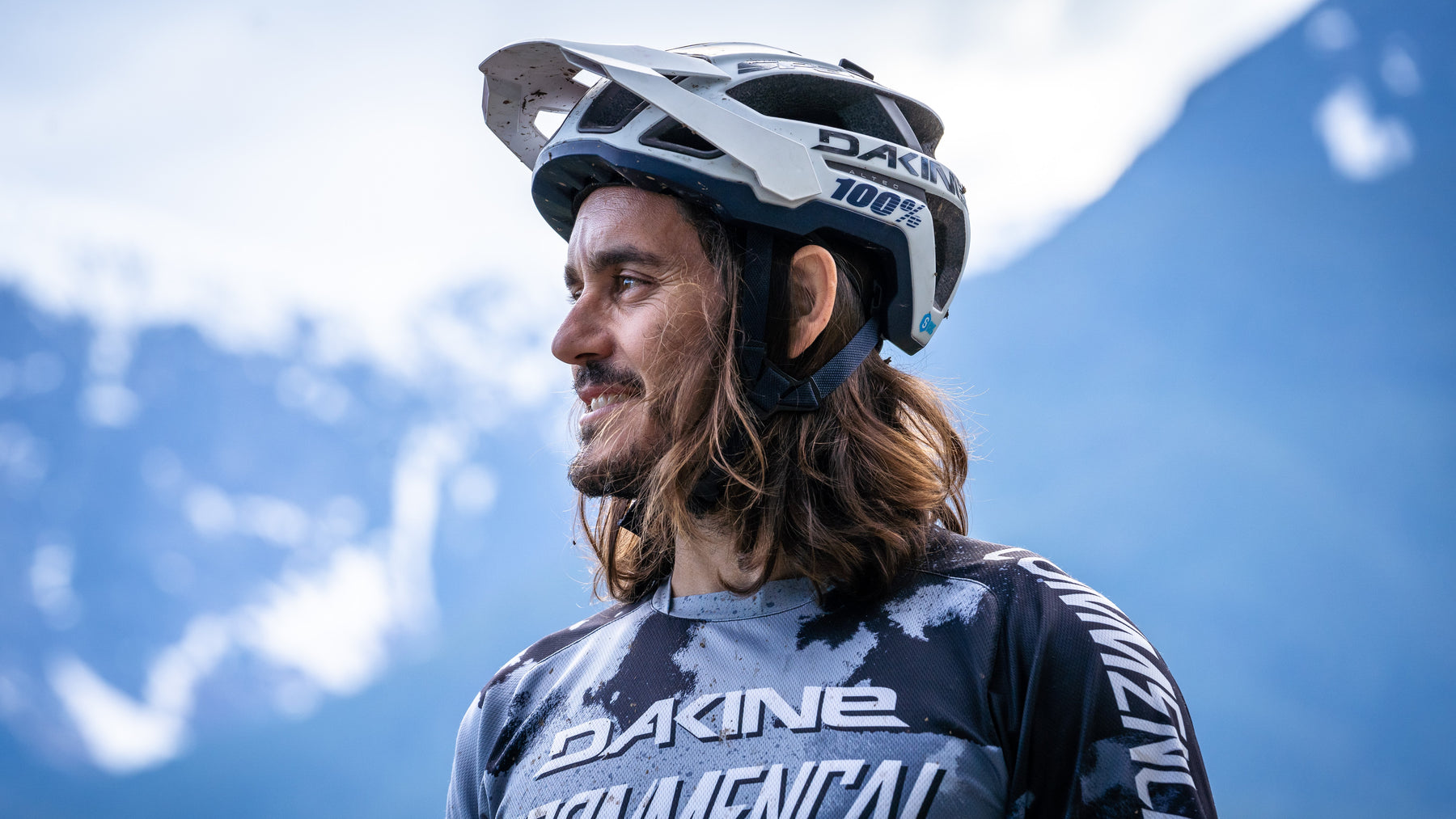 Yoann Barelli, professional mountain biker. Image of him in riding gear with mountains in the backdrop