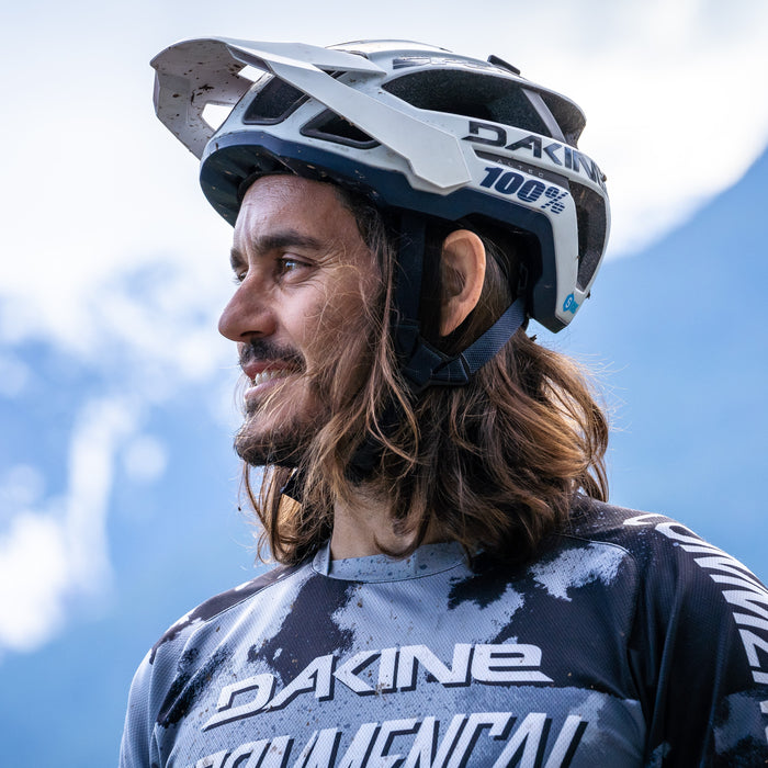 Yoann Barelli, professional mountain biker. Image of him in riding gear with mountains in the backdrop