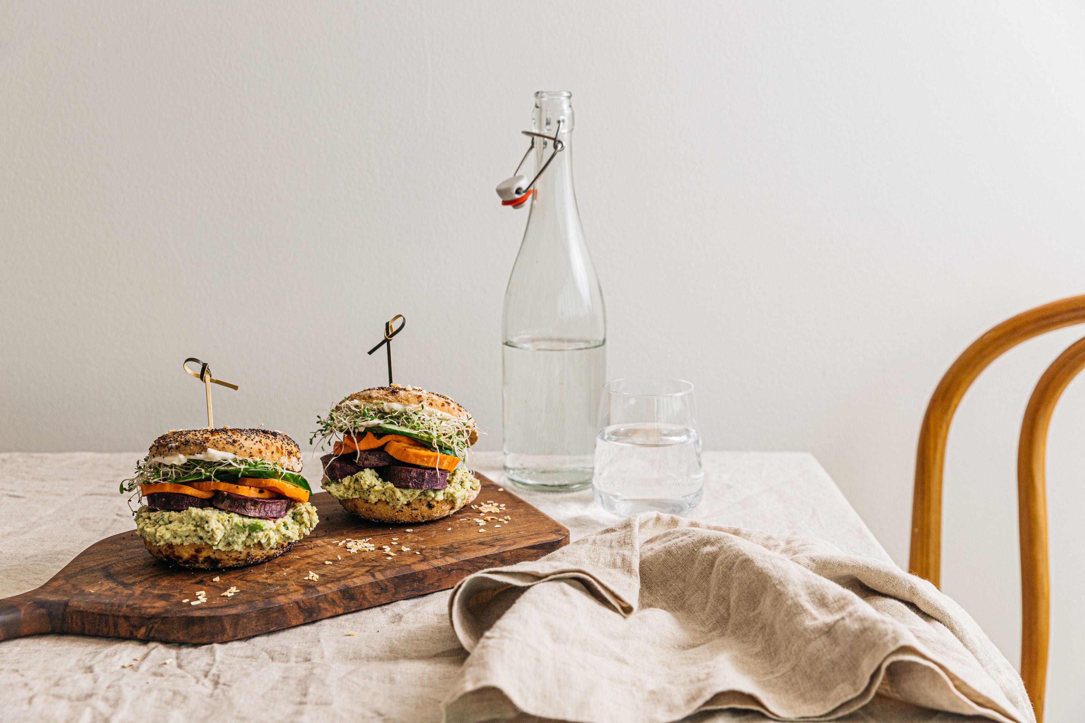 Stacked Alkeme gluten-free sourdough everything bagels with fresh vegetables and creamy spreads, perfect for a healthy breakfast or brunch